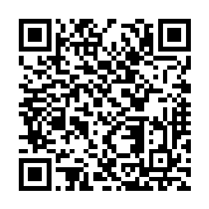 一个校工模样的中年男人在指挥人往外抬旧办公桌二维码生成