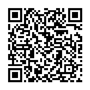 穿着整齐的居家服站在门口用毛巾擦着湿漉漉的头发二维码生成